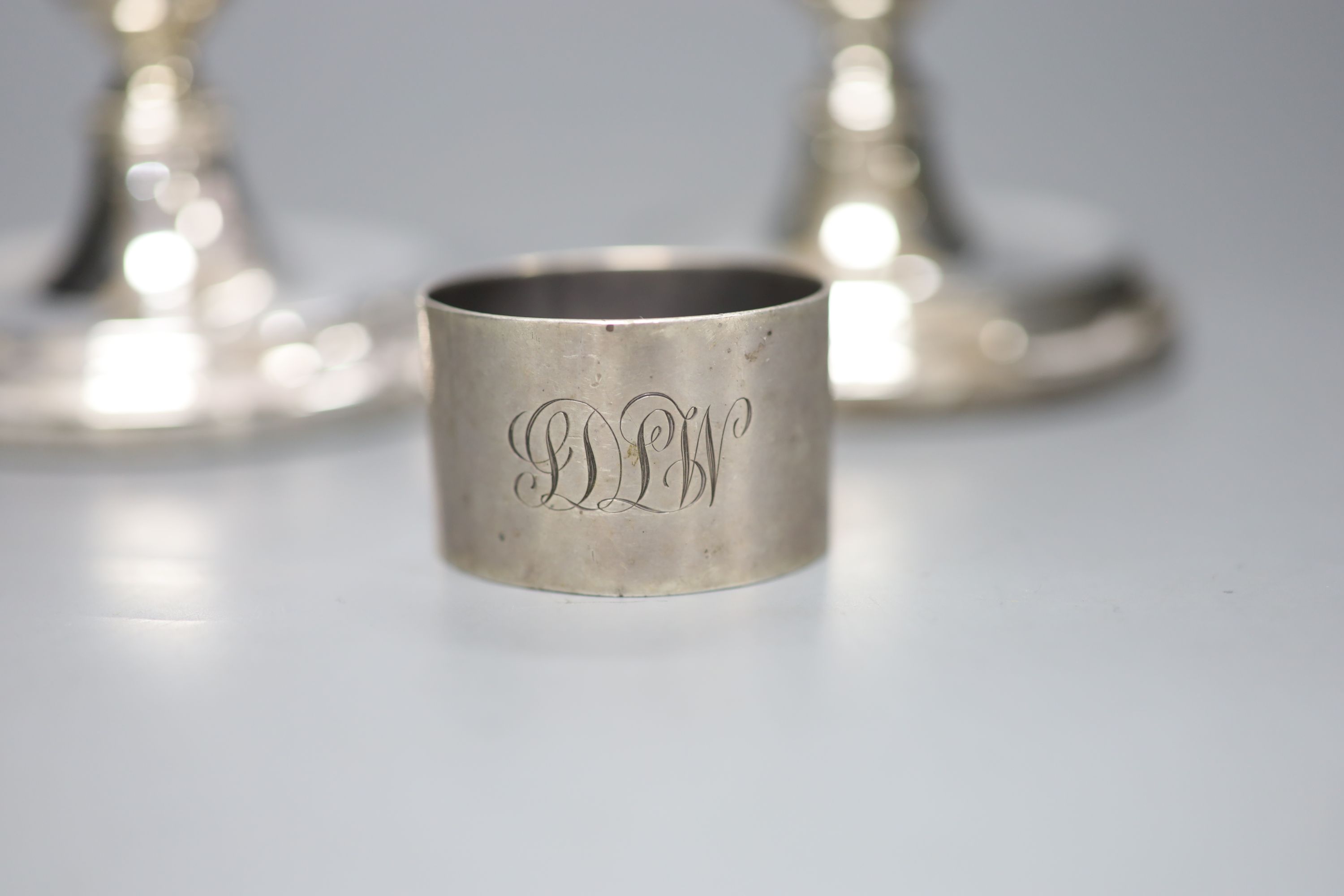 A pair of modern silver dwarf candlesticks, 12cm, a silver napkin ring and four sterling napkin rings.
